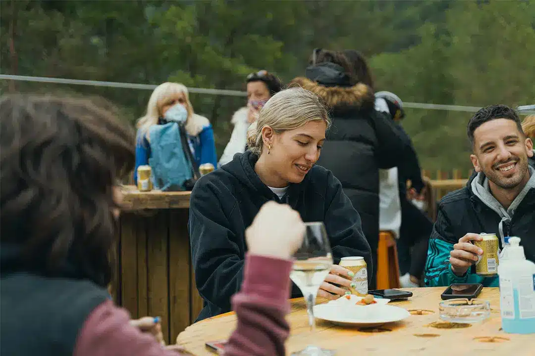 Grupo de personas disfrutando en la terraza del bar de la Tirolina.