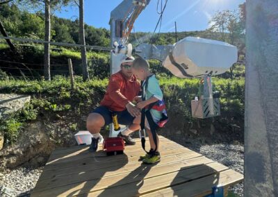 Niño con el encargado preparando el salto en la TyrolKid, la tirolina infantil.